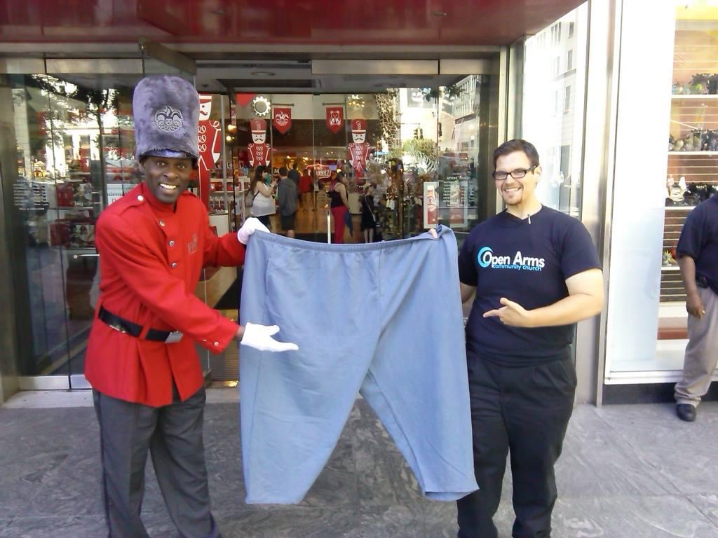 Justin holding the 80-inch waist pants he wore at 799 pounds